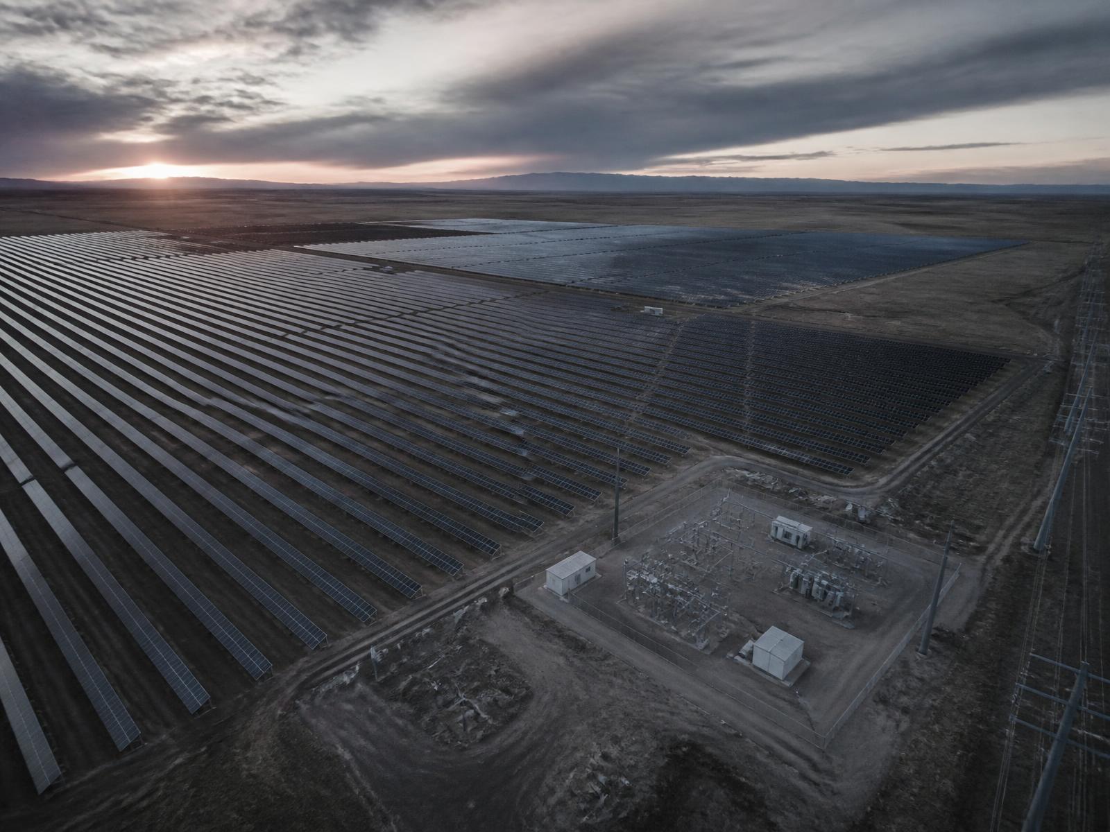 Aerial view of a utility-scale solar project and its collector substation at dusk
